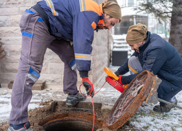 Plumbers Checking Sewer Manhole With Borescope Inspection Camera